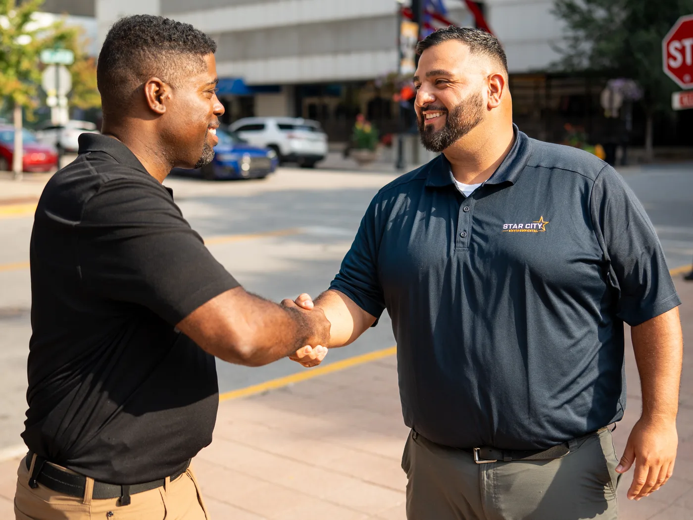 A Star City Environmental representative shaking hands with a customer on a downtown street.