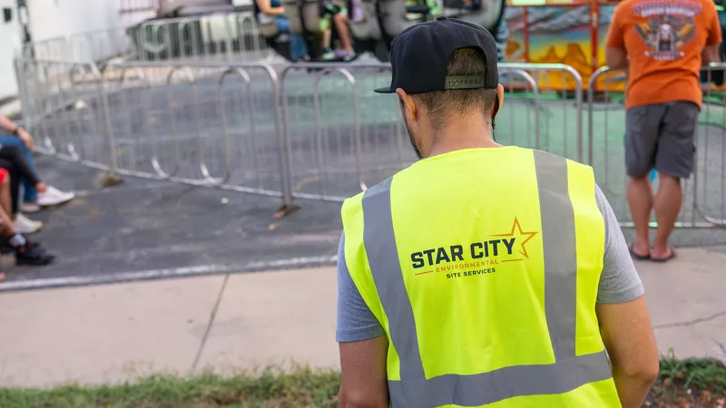 A Star City Environmental crew member servicing bins on a carnival midway.